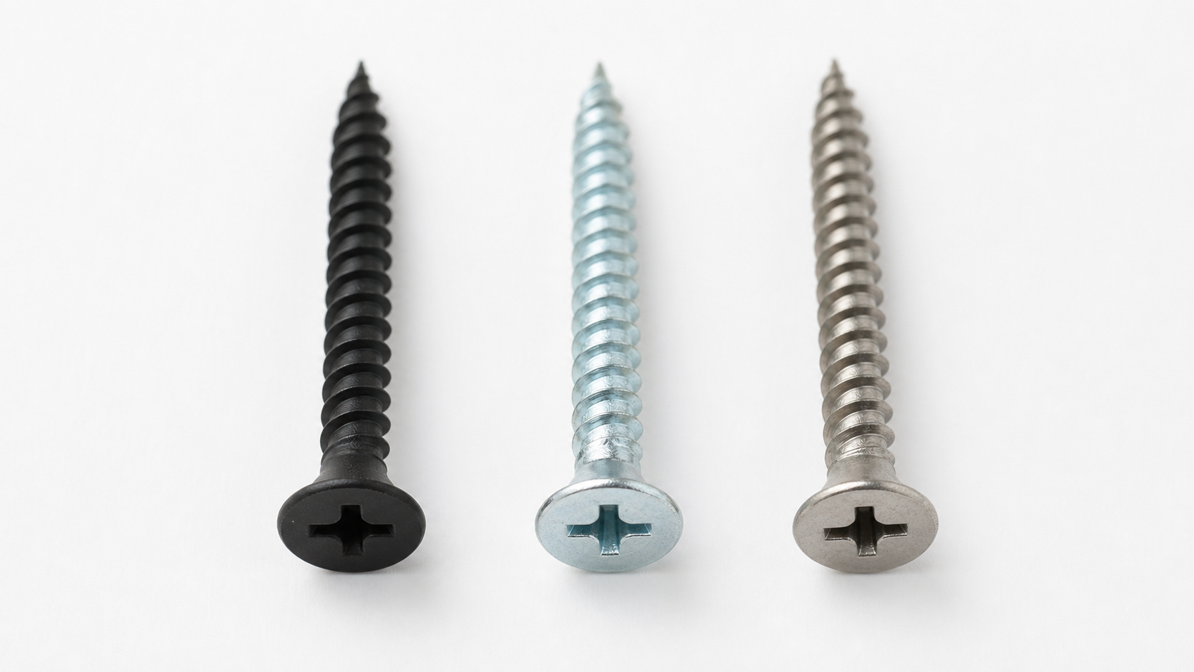 Flat-lay comparison of three drywall screws with different finishes: matte black phosphate, bright silver galvanized, and nat