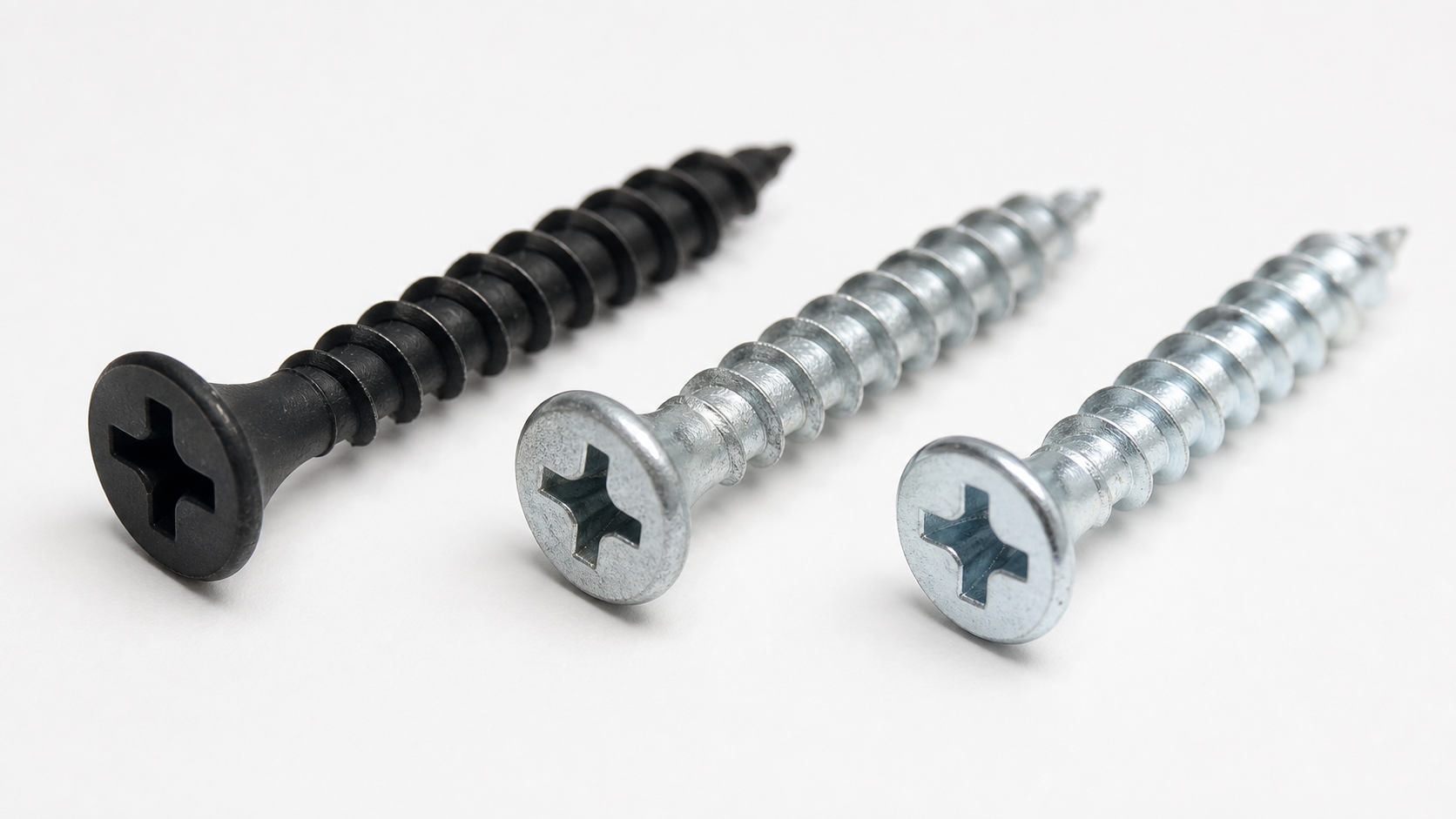 Comparison of three drywall screw finishes: matte black phosphate, silver galvanized zinc, and bright electro-zinc plated.